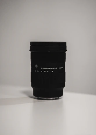 Close-up of a camera lens focused on a luxury product, surrounded by minimalist styling props.