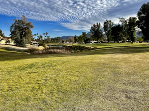 A wide-angle shot of the Villa María Golf Club's lush green fairways under a clear blue sky.