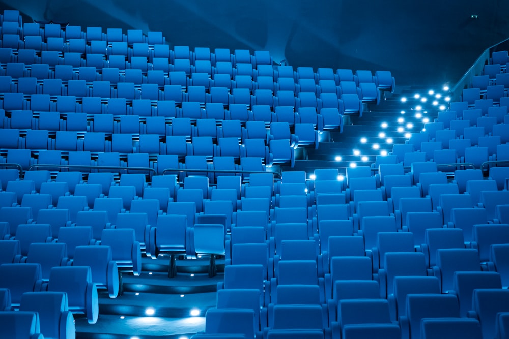 a row of empty blue chairs in a theater
