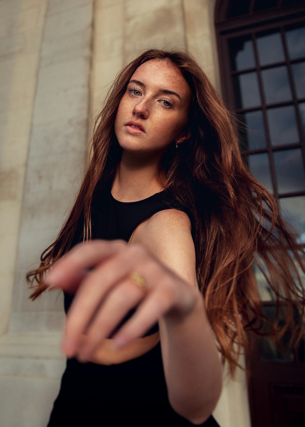 a woman with long hair pointing at something