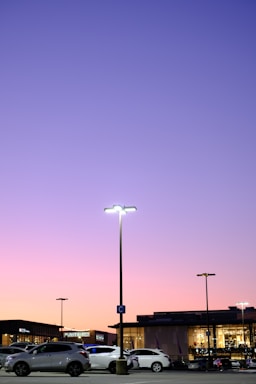 A modern parking lot with clear markings and parked cars under daylight.