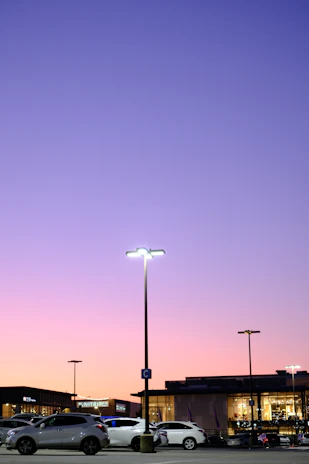 PTZ camera capturing a wide-angle view of a busy parking lot at dusk.