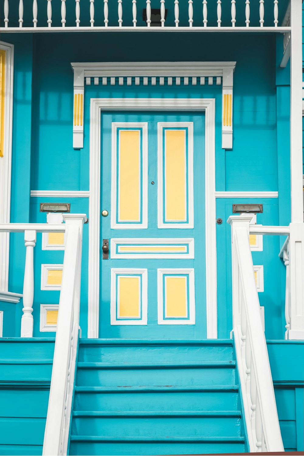 a blue and white house with a yellow door