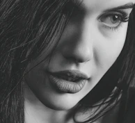 A close-up of a woman’s smile, lips slightly parted, evoking mystery and allure.