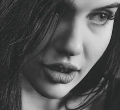 A close-up of a confident woman with a mysterious smile, evoking allure.