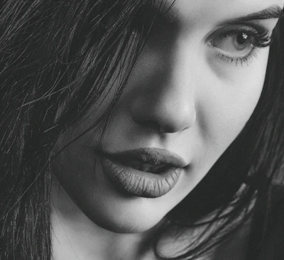 Close-up of a confident woman with a mysterious smile, highlighting allure.