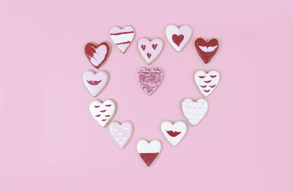 a group of heart shaped cookies on a pink background