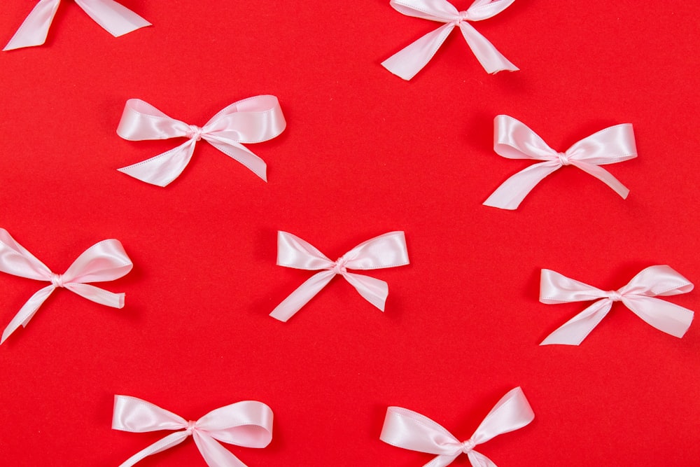 a group of white bows on a red background