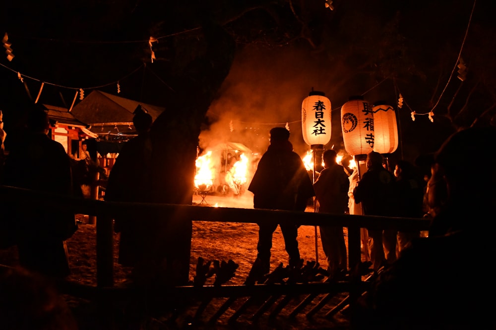 a group of people standing around a fire