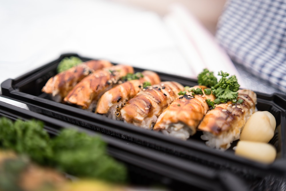 a couple of black trays filled with sushi