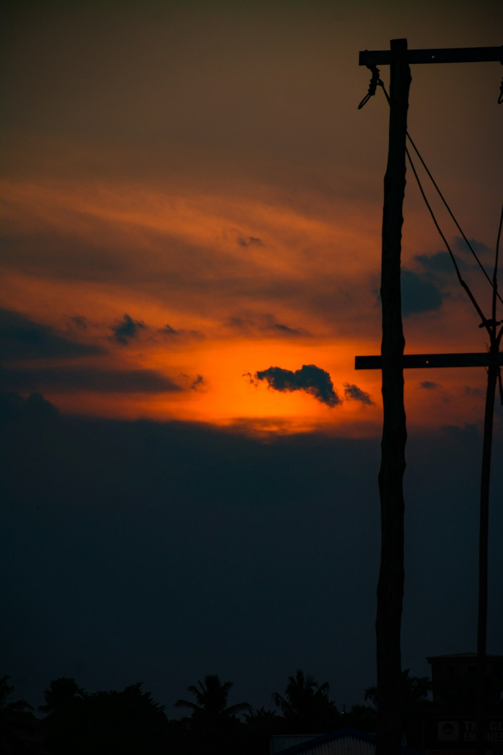 the sun is setting behind a telephone pole