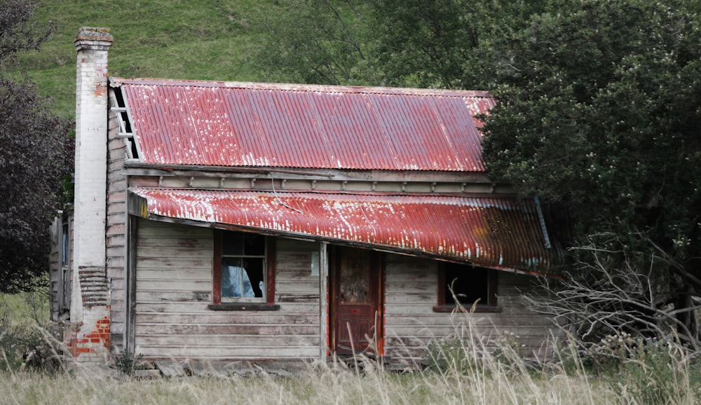 an old run down building with a red tin roof