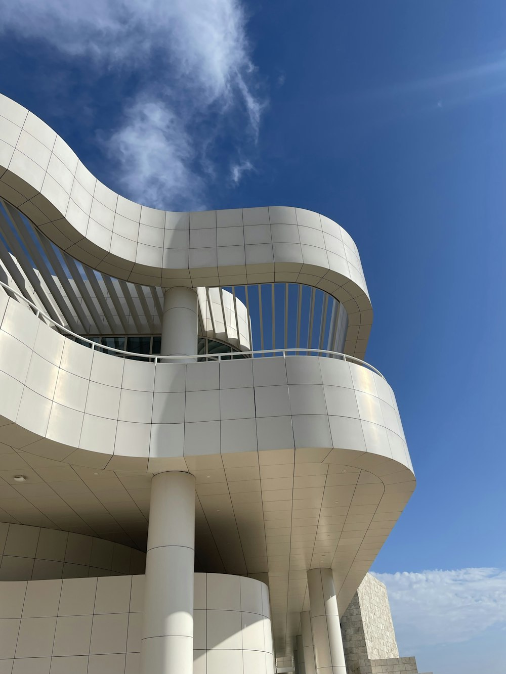 a large white building with a balcony and a sky background