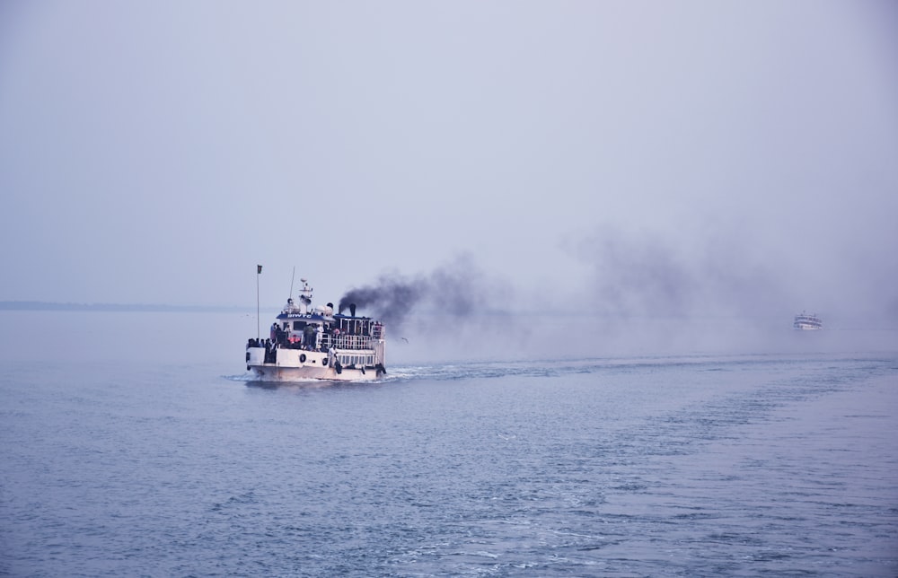 a boat with smoke coming out of it on the water