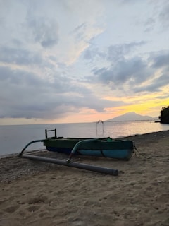 A vibrant Hawaiian outrigger canoe on the calm waters at Marataízes beach during sunset.