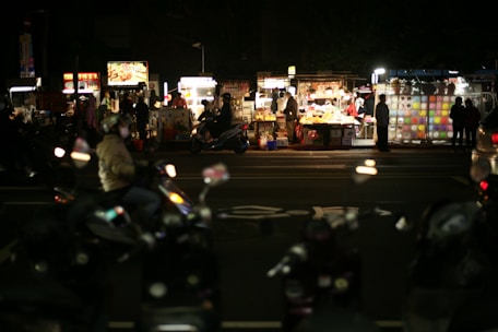 Backpacker enjoying street food in a vibrant Vietnamese market at sunset.