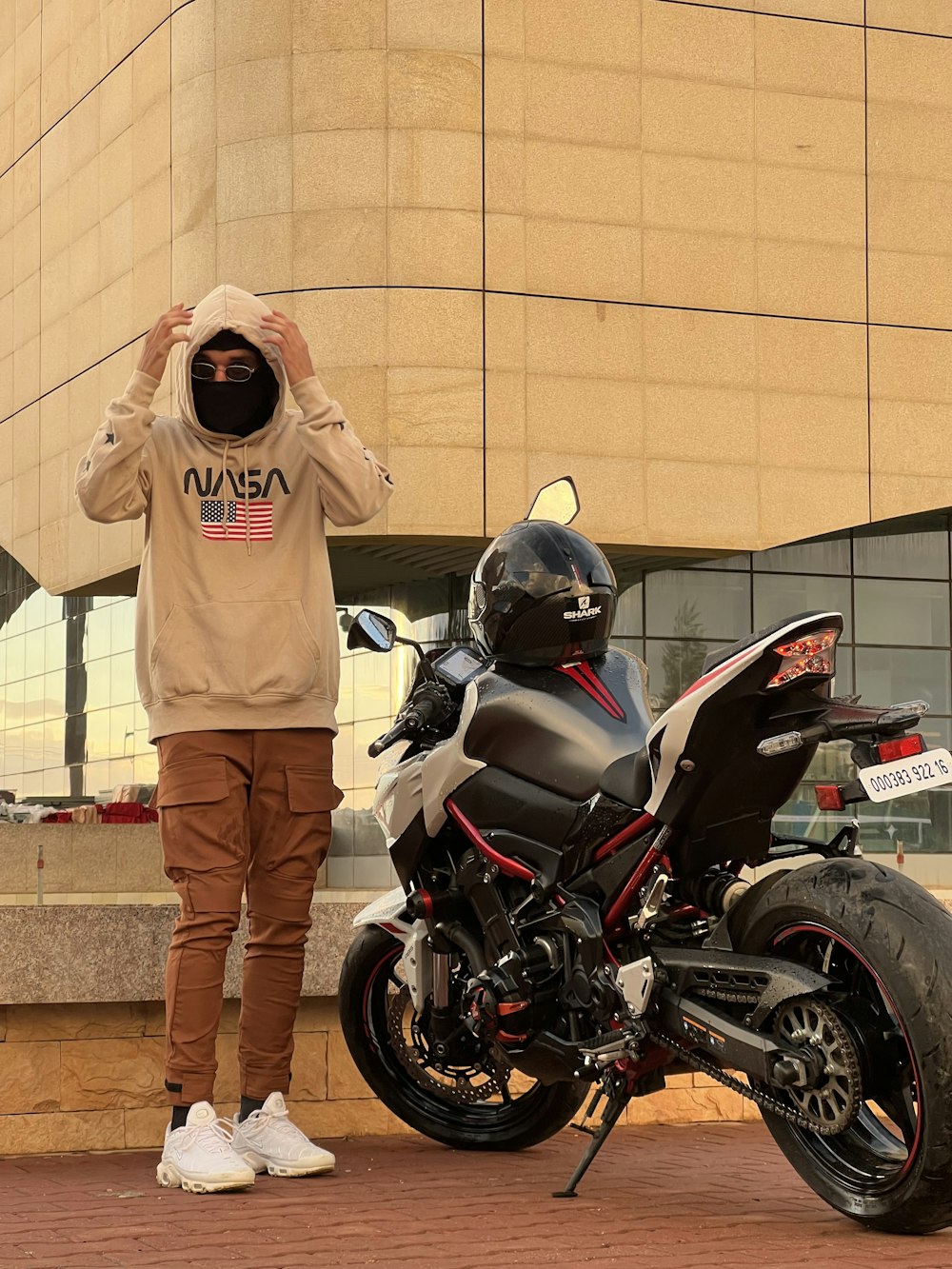 a man standing next to a parked motorcycle