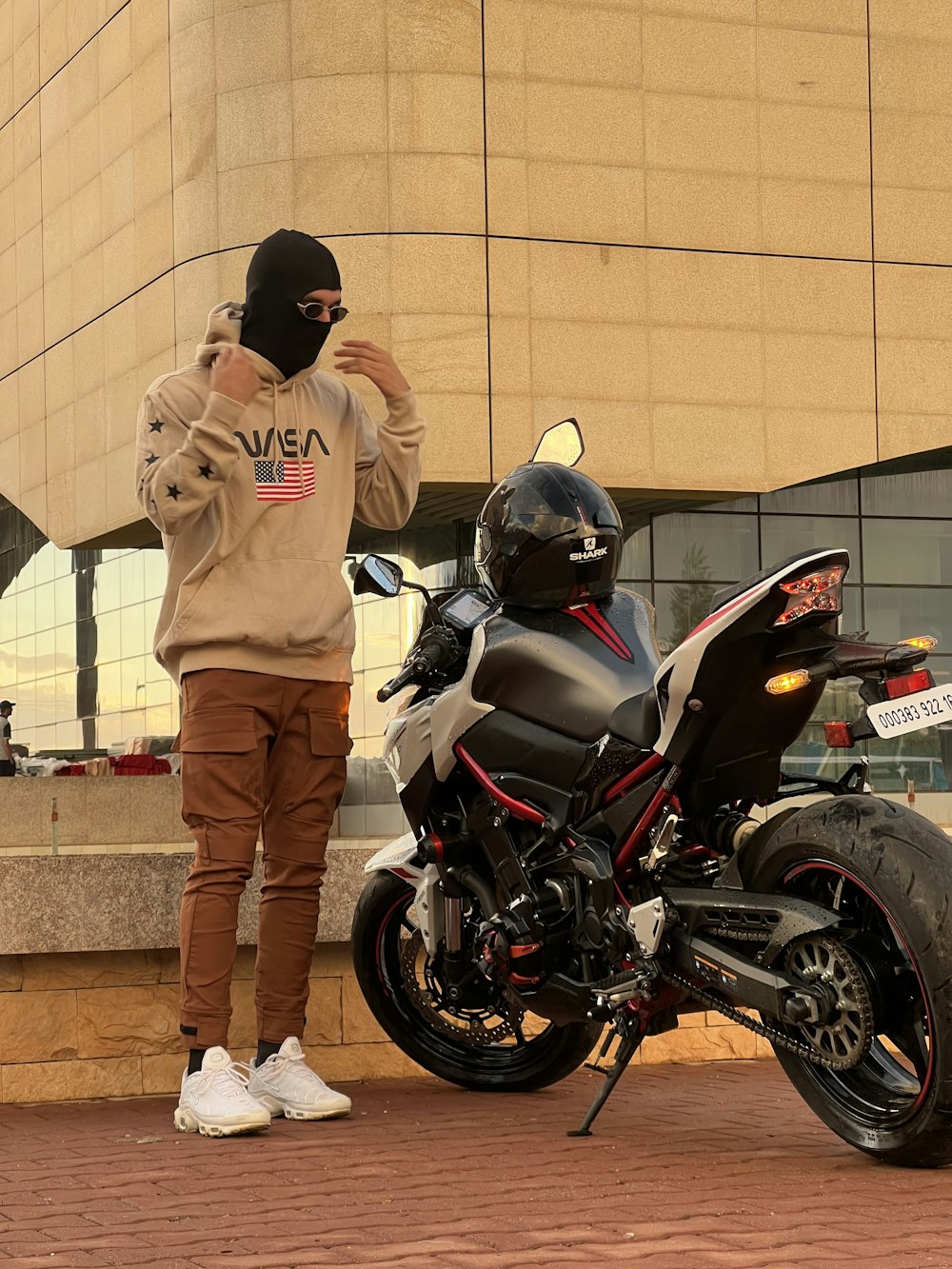 a man standing next to a parked motorcycle