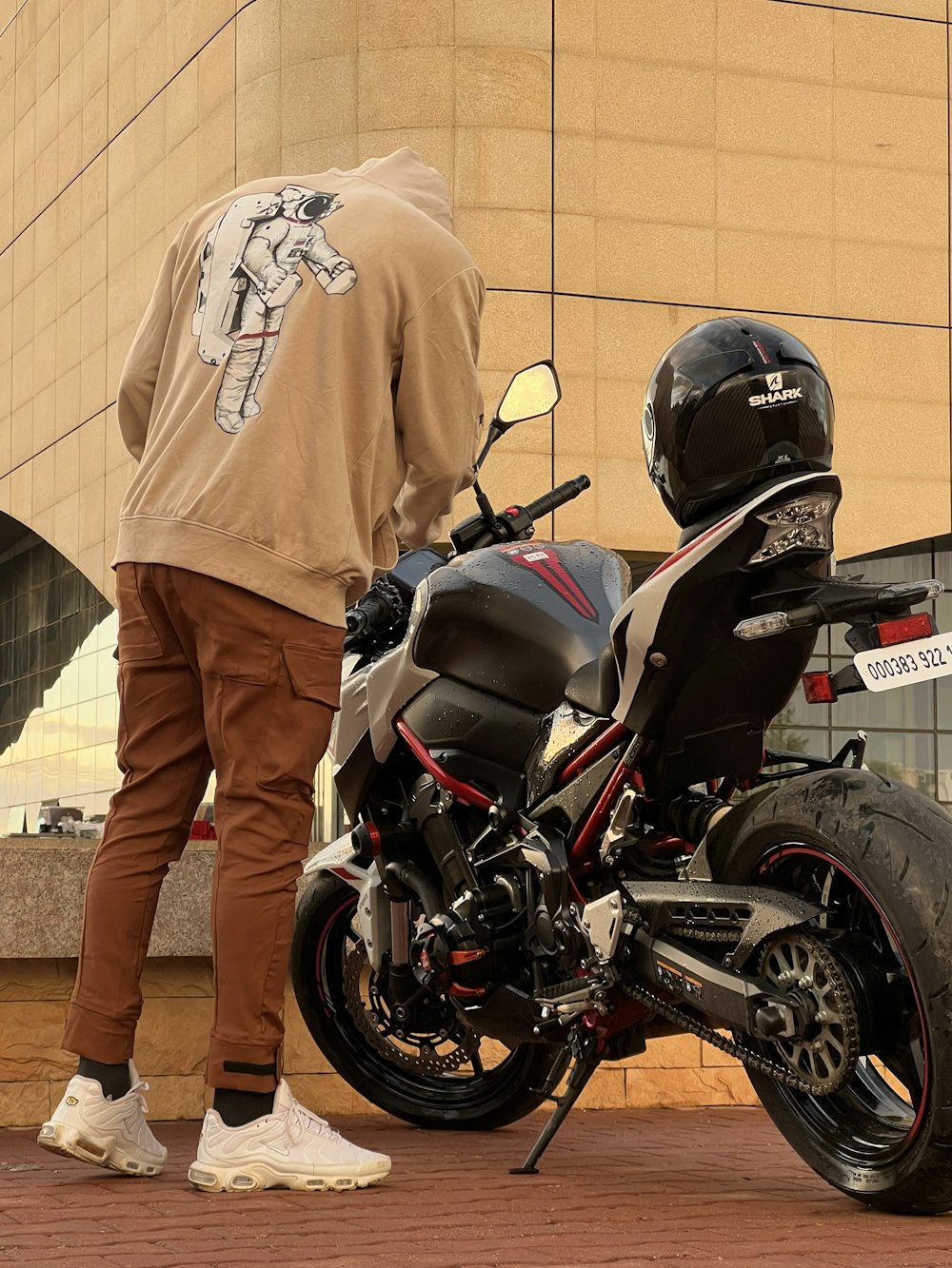 a man standing next to a parked motorcycle