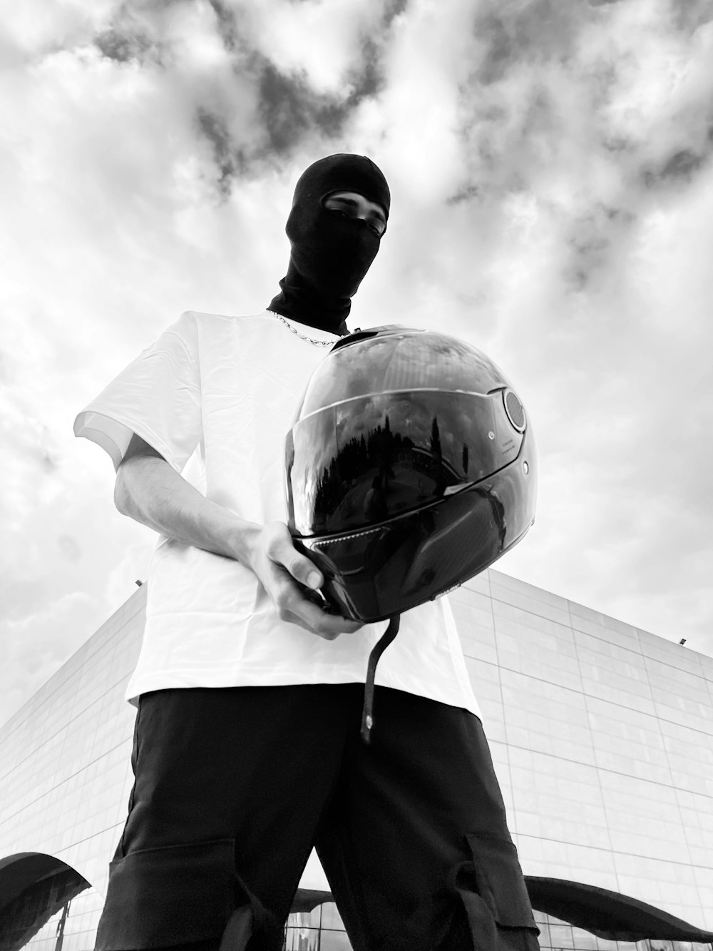 a man wearing a helmet standing in front of a building