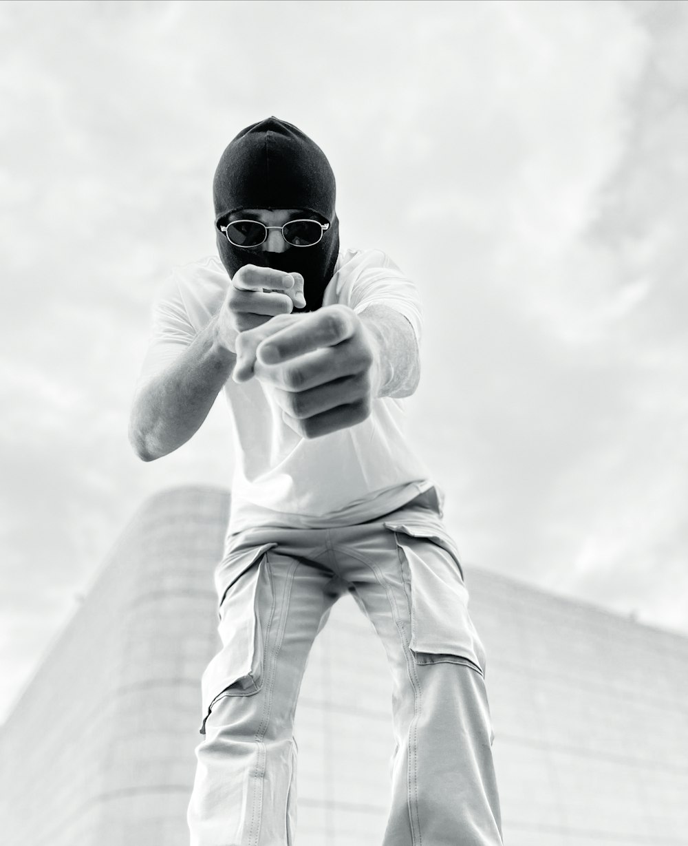 a man in a white shirt and black helmet is using a cell phone