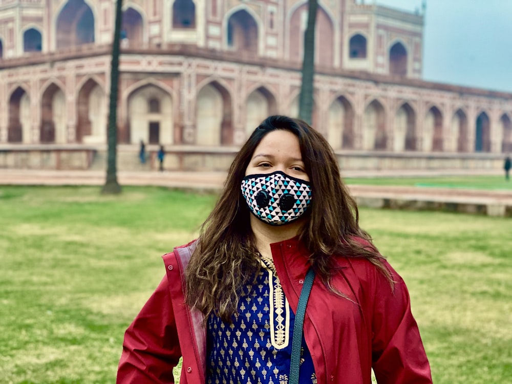 a woman wearing a face mask in front of a building