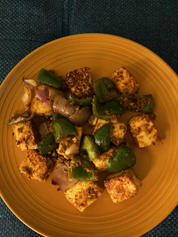 Close-up of creamy soy paneer cubes on a rustic wooden board with fresh herbs.