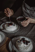 A chef carefully adding final touches to a delicate cake topped with fresh berries