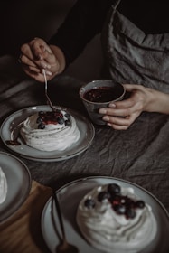 A chef carefully garnishing a traditional Italian dessert with fresh berries.