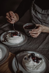 A chef carefully garnishing a traditional Italian dessert with fresh berries.