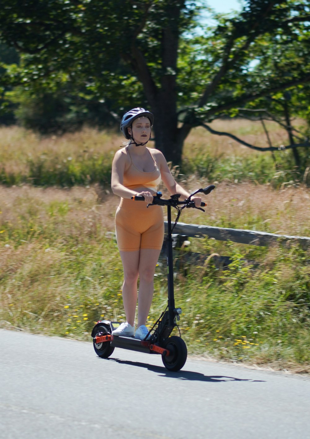 a woman riding a scooter down a road