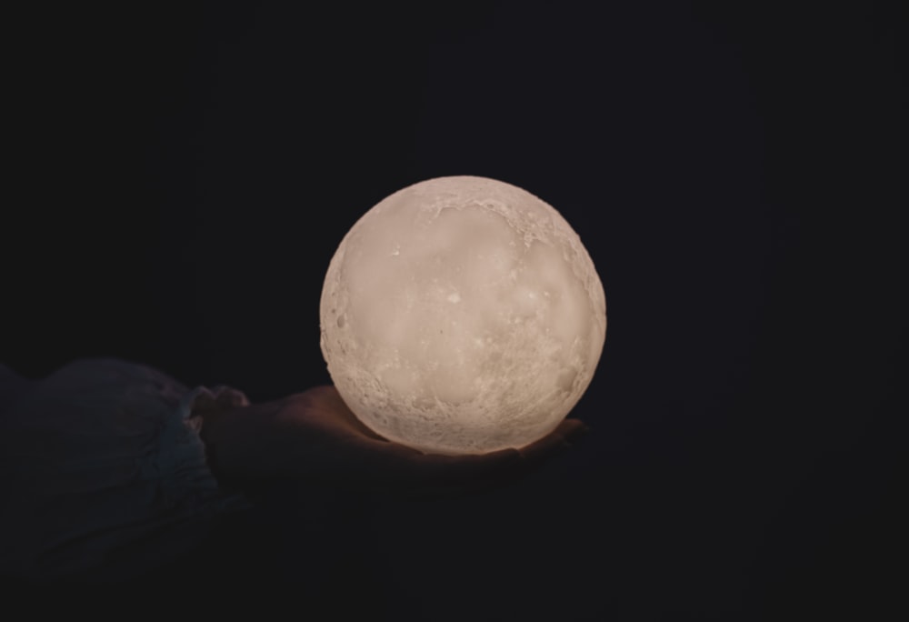 a person holding a large white ball in their hand