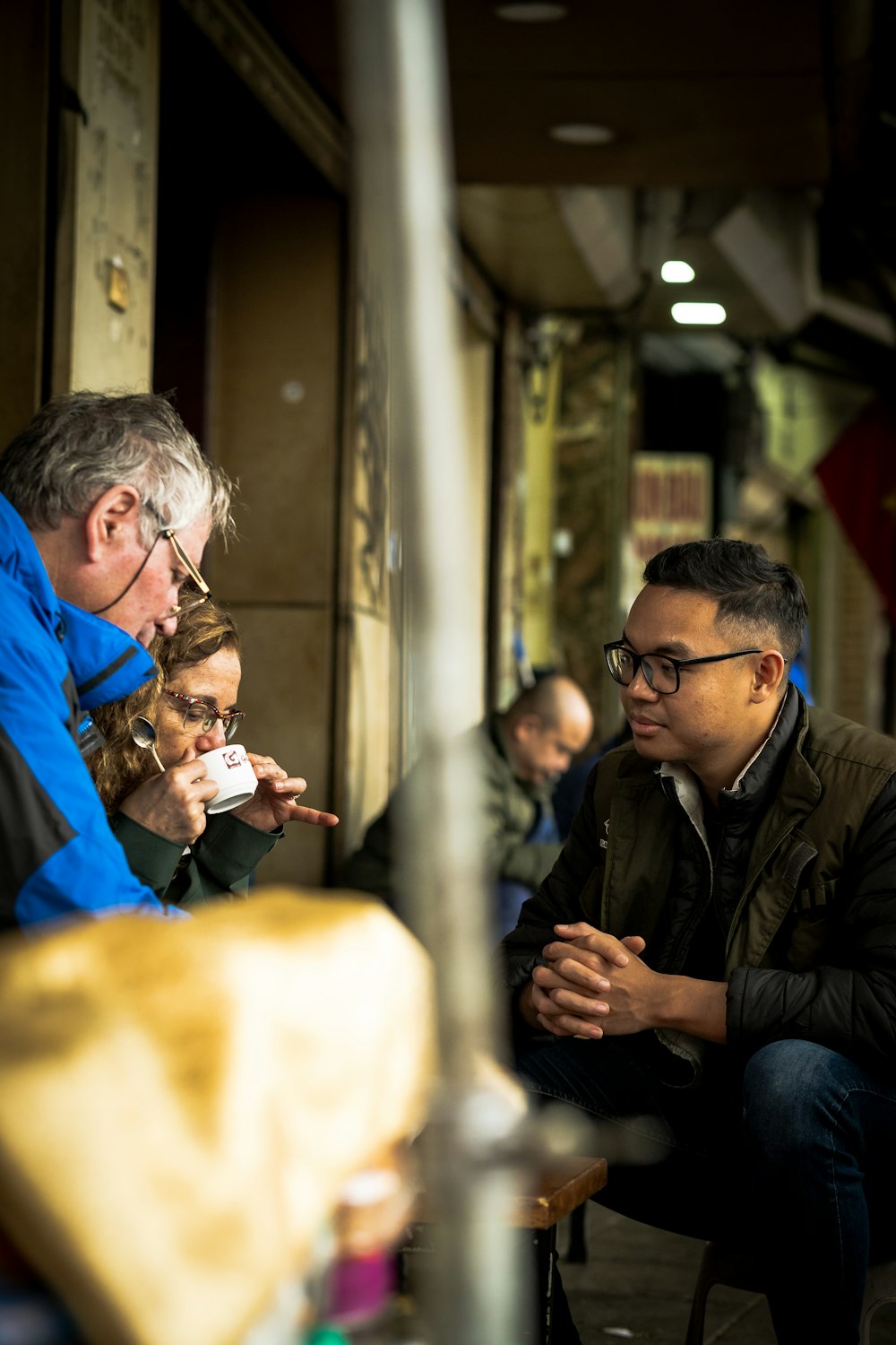 a group of people sitting on a bench eating food