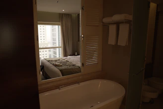 Plush towels hanging in a bright, modern bathroom with black and white accents.