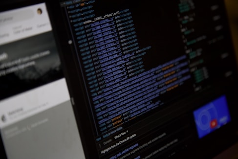 Close-up of hands coding a website interface on a desktop monitor.