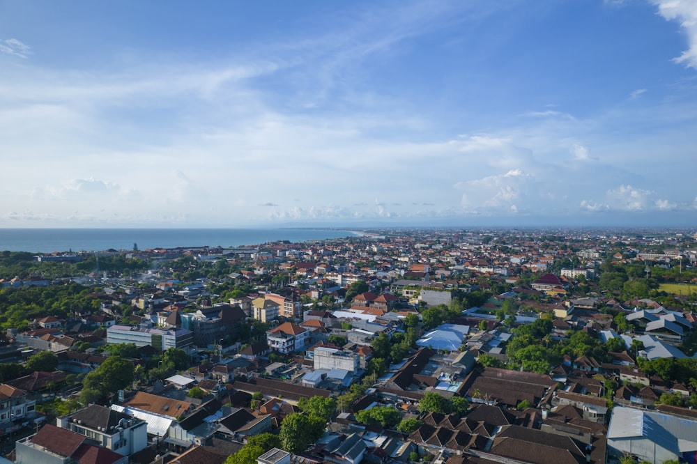 an aerial view of a city with a body of water in the background