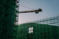 Safety nets stretched taut around a busy construction area during daytime.
