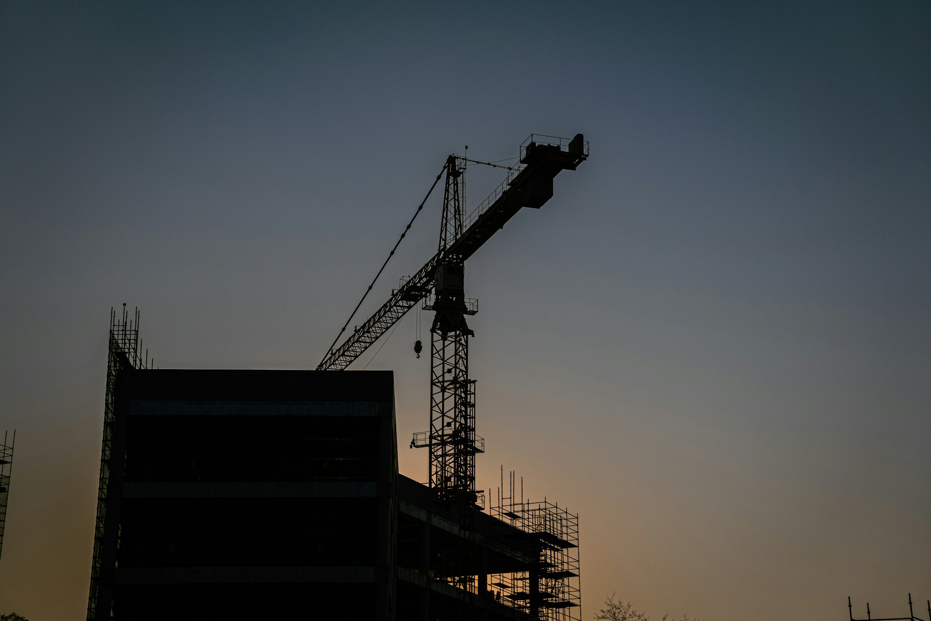 a crane is silhouetted against the evening sky