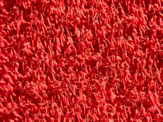 Detailed shot of a durable PVC swirl mat with vibrant colors in a retail store setting.