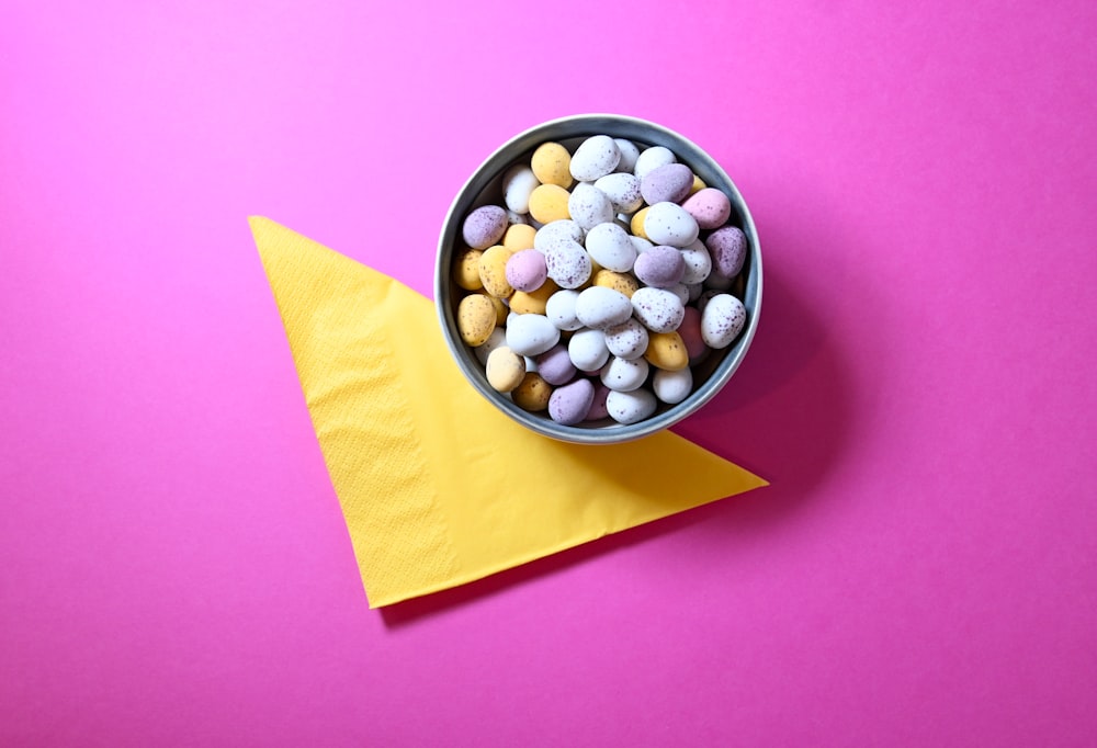 a bowl filled with candy sitting on top of a yellow napkin