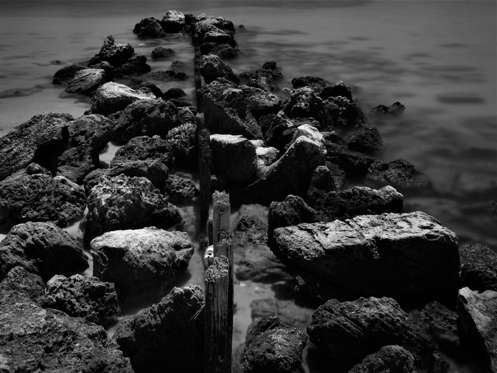 a black and white photo of rocks and water