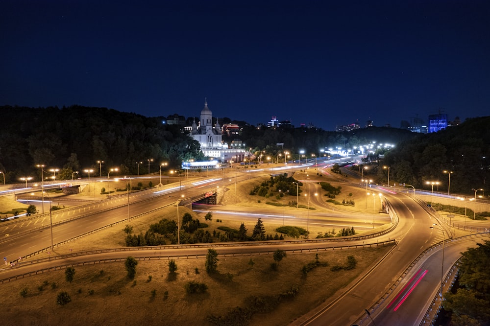 a night time view of a highway with a city in the background