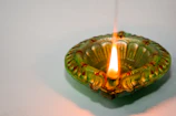 Traditional Kerala lamp (Nilavilakku) glowing warmly against a backdrop of tropical greenery.