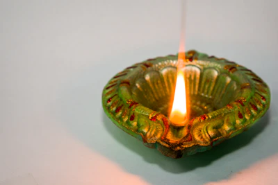 Traditional Kerala lamp (Nilavilakku) glowing warmly against a backdrop of tropical greenery.