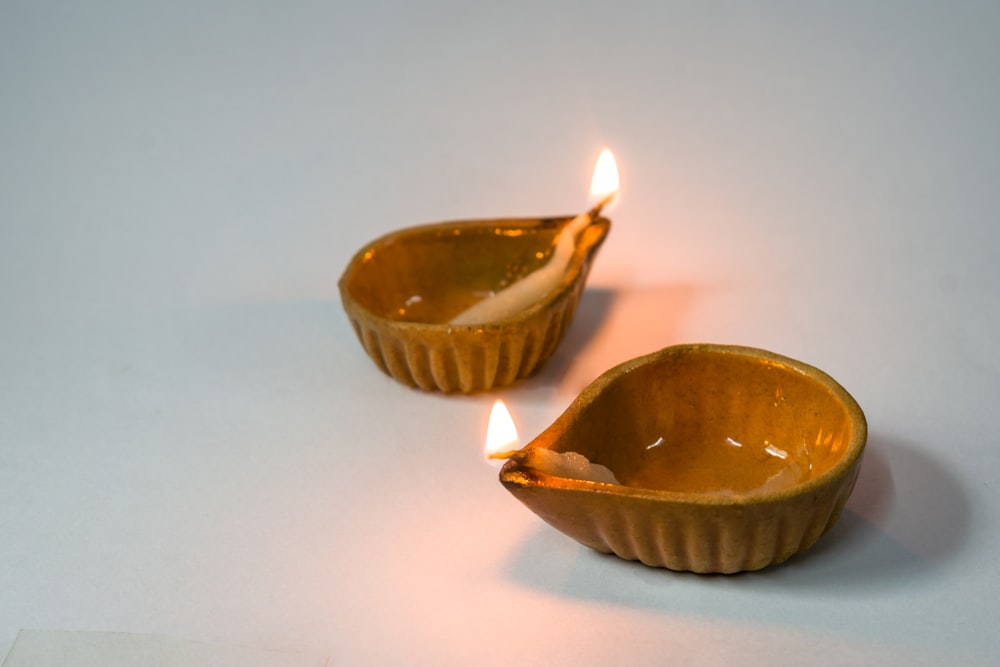 a couple of candles that are in some kind of bowl