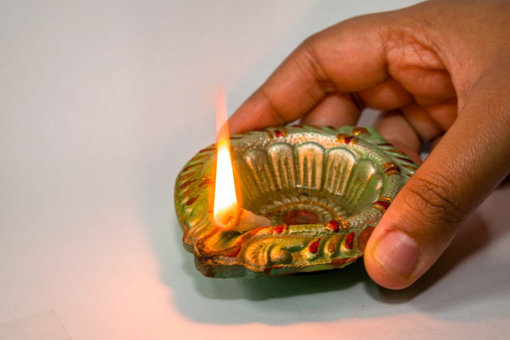 a person holding a small candle in their hand