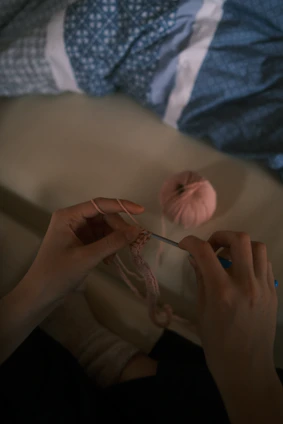 Close-up of hands skillfully crocheting a delicate pattern with natural yarn.