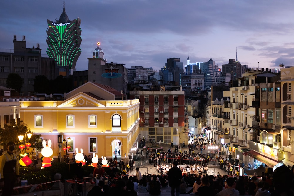 a crowd of people walking down a street next to tall buildings