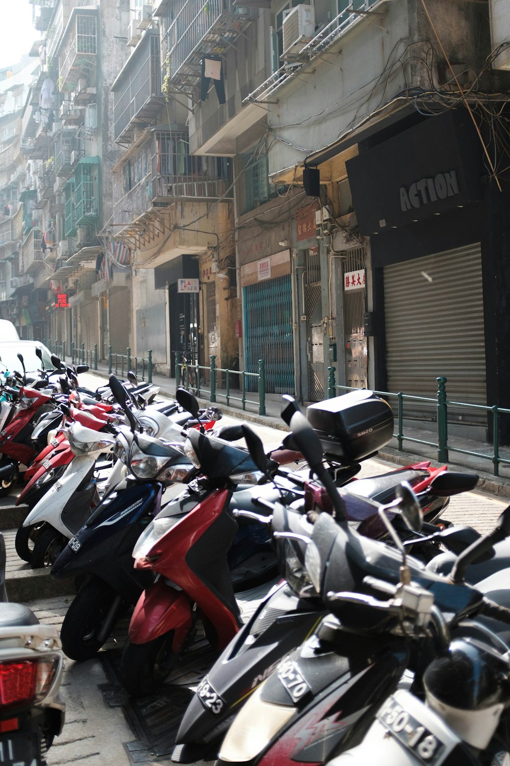a row of motor scooters parked on the side of a street