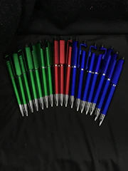 Custom printed promotional pens in sky blue and red arranged neatly on a desk.